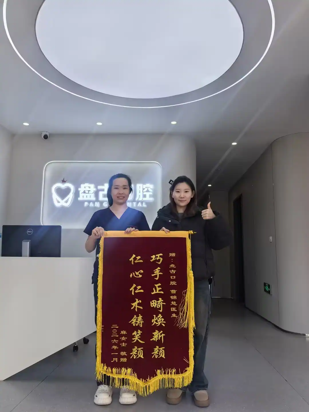 患者与曹锦慧主任展示致谢锦旗的合影