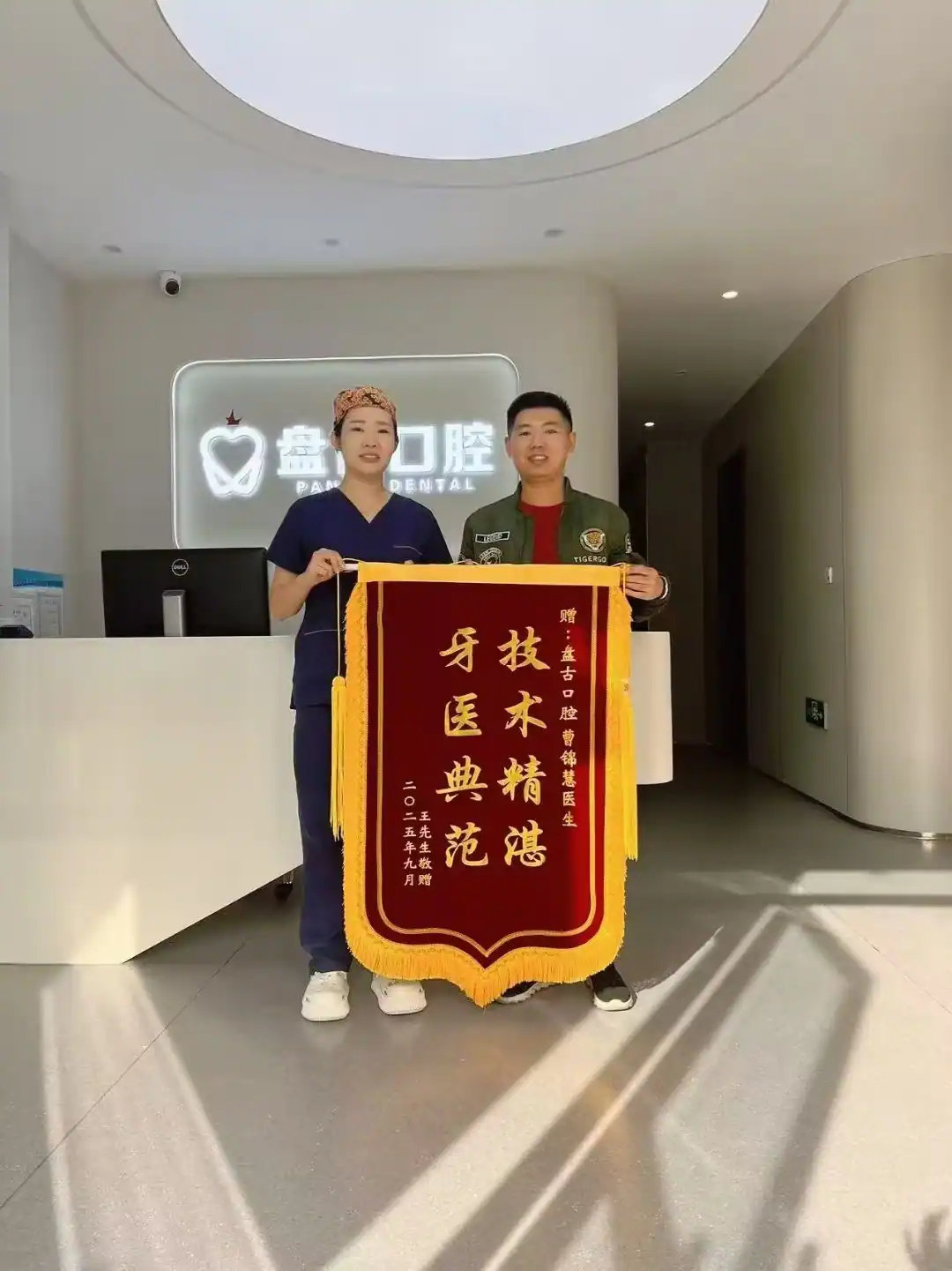 患者与曹锦慧主任展示致谢锦旗的合影
