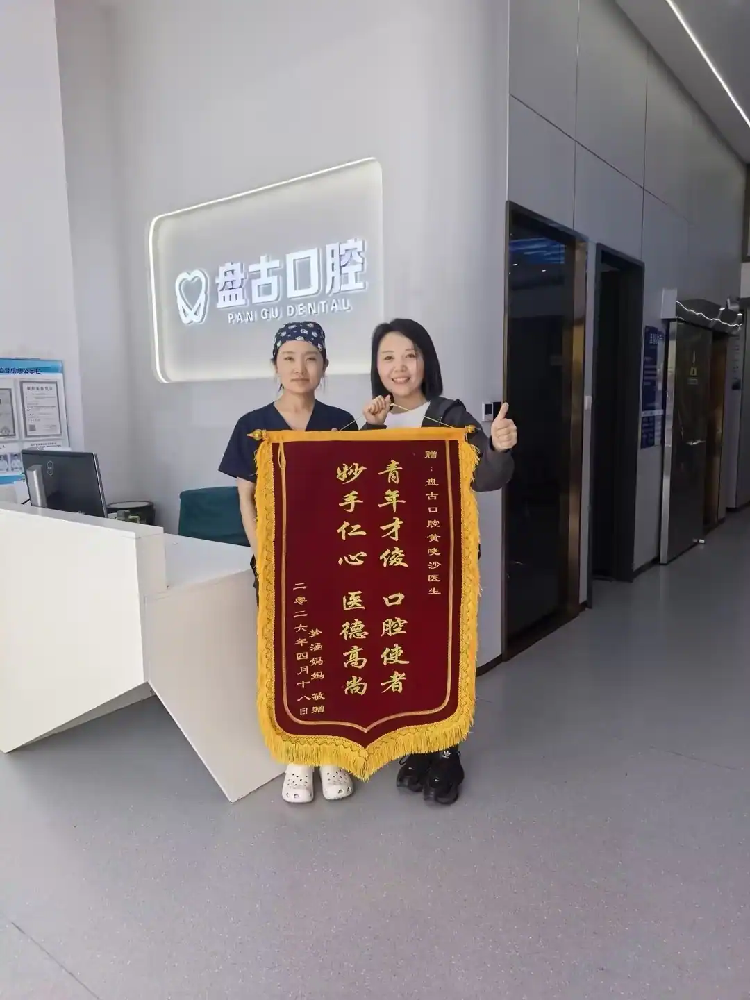 儿童患者家属与医护人员展示致谢锦旗的合影