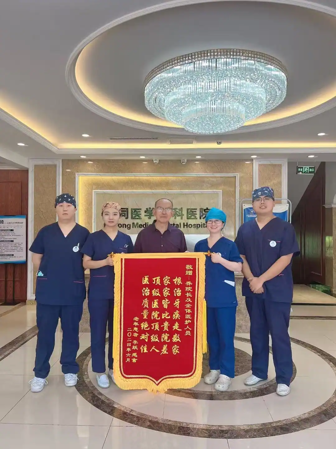患者与医护团队展示致谢锦旗的合影